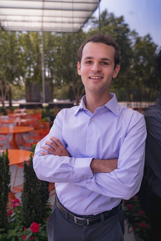 Smiling professional in a lavender shirt with arms crossed
