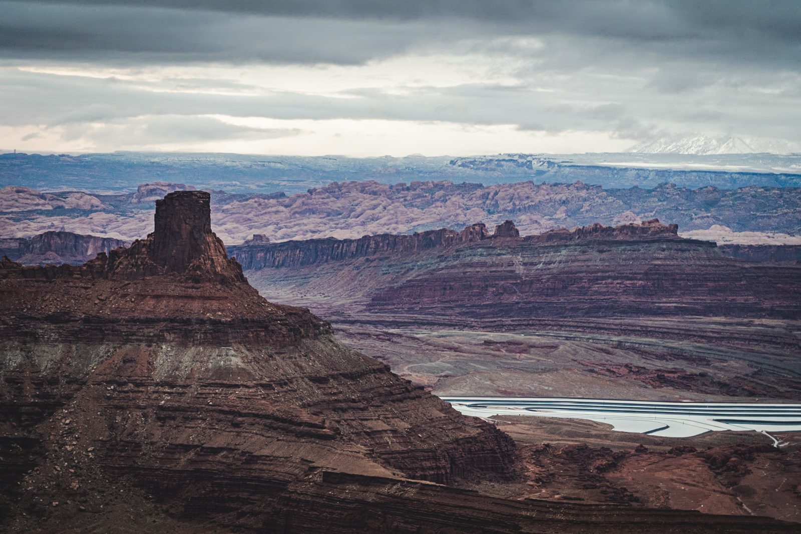 Layered red rock canyon landscape beneath heavy clouds